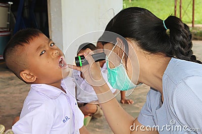 Doctor is checking the oral cavity of a student. Editorial Stock Photo